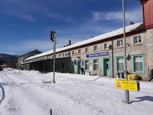 a snow covered street in front of a building at Dopravna Alžbětín in Železná Ruda
