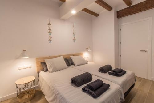 ein Schlafzimmer mit 2 Betten und schwarzen Kissen darauf in der Unterkunft El Mariner in Sant Carles de la Ràpita