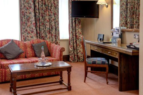 a hotel room with a couch and a table at Crown & Mitre Hotel in Carlisle