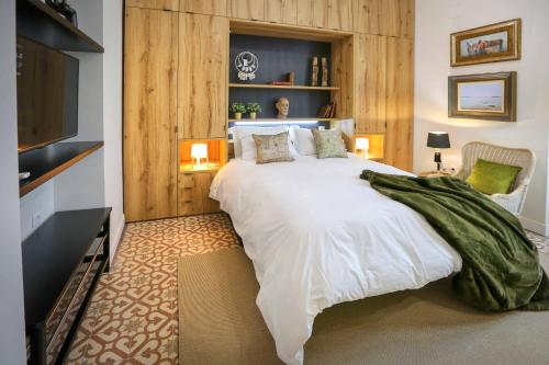 Un dormitorio con una gran cama blanca y un televisor. en A ESCONDIDASs, en Ayamonte