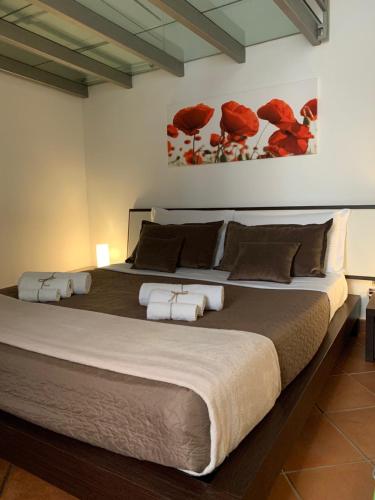 a large bed in a bedroom with red flowers on the wall at Casa vacanze Ai Corrieri in Palermo