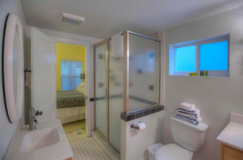 uma casa de banho com um chuveiro, um WC e um lavatório. em Havana Inn em St. Pete Beach