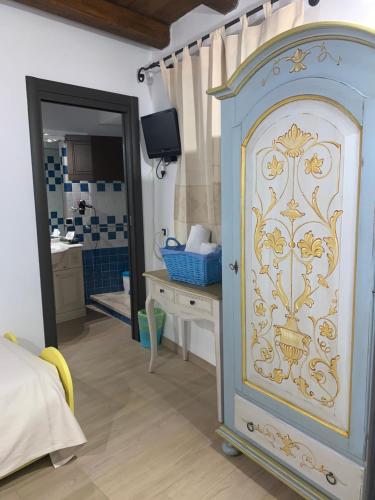 a bedroom with a blue and white cabinet with a mirror at Antica Potecarìa in Tonara