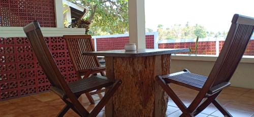 einen Tisch und Stühle auf einer Veranda in der Unterkunft Bunga Ayu Seaside Resort in Pelabuhan Ratu