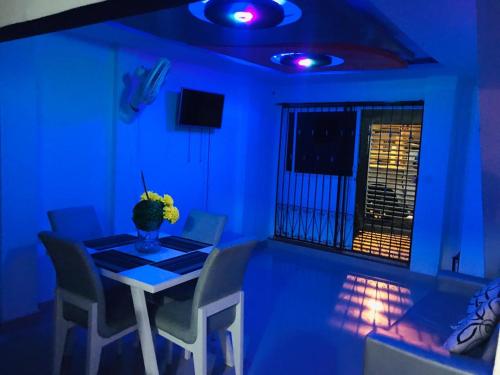 Cette chambre bleue dispose d'une table, de chaises et d'une fenêtre. dans l'établissement APARTAMENTO CON EXCELENTE UBICACION Barrio Canapote kr 17#61-39, à Carthagène des Indes