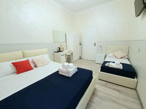 um quarto com 2 camas e toalhas em Oscar suite home em Roma