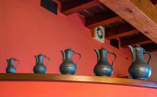 a row of pitchers on a wooden shelf at Antiche Vie B&B in Serramazzoni