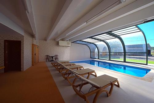Habitación con piscina, sillas y ventanas. en Hostal Palouet de Segarra, en Massoteres