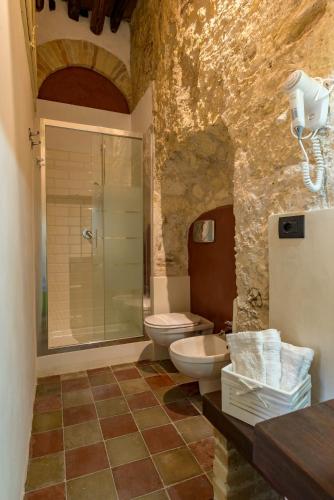 a bathroom with a toilet and a glass shower at Cappuccine GuestHouse in Cagliari
