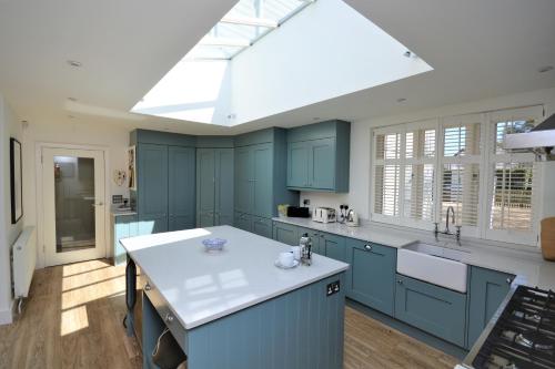 una grande cucina con armadi blu e lucernario di Hope Cottage a Bembridge