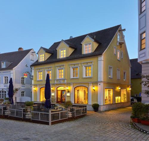 a large building with umbrellas in front of it at Lodner Hotel Drei Mohren in Lauingen
