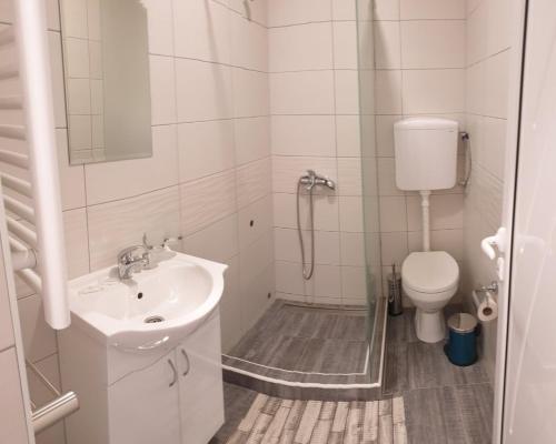 a white bathroom with a sink and a toilet at Vaš Kutak 2026 - Sobe Lux za izdavanje in Obrenovac