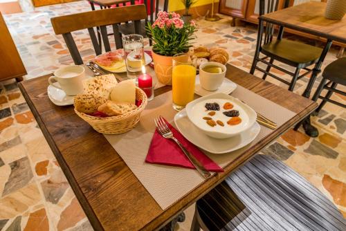 Una mesa de desayuno con alimentos para desayunar y jugo de naranja. en Cappuccine GuestHouse, en Cagliari