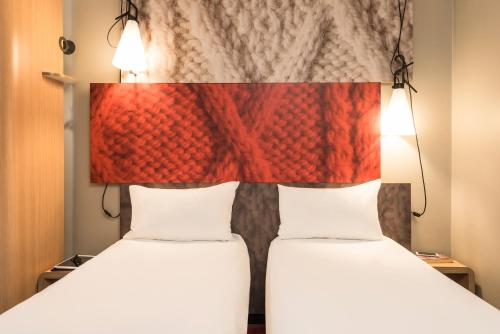 two beds in a room with a headboard at ibis Manchester Centre 96 Portland Street in Manchester