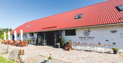 a building with a red roof and benches in front at Vetsi Talli Holiday Village in Kassari