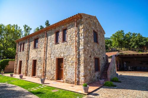 a large stone building with brown doors in a yard at Casena Mongerrati in Collesano