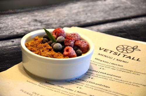a bowl of berries sitting on top of a menu at Vetsi Talli Holiday Village in Kassari
