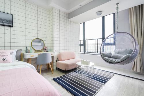 a bedroom with a bed and a chair and a mirror at Quzhu Apartment Hotel (Wuhan Hankou Railway Station) in Wuhan