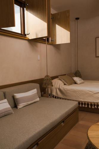 a room with two beds and a couch and a window at Casa Montore by Barrio Mexico in Guadalajara