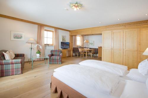 a bedroom with two beds and a living room at Hotel Angela in Lech am Arlberg