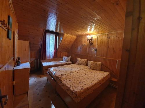 um quarto com 2 camas num quarto de madeira em Silentium Clavem Domus I. em Satu Mare