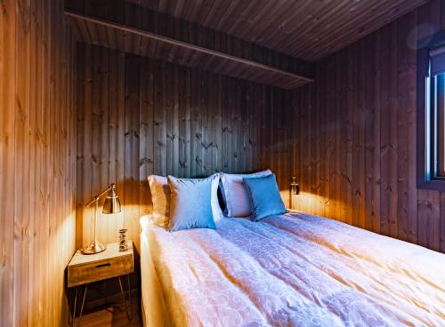 ein Schlafzimmer mit einem Bett mit einer Holzwand in der Unterkunft Seljalandsfoss Horizons in Hvolsvöllur