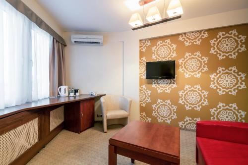 a hotel room with a desk and a tv on a wall at Adria Hotel in Kyiv