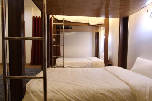 a bedroom with two bunk beds with white sheets at Himalaya Sapa Hotel in Sa Pa