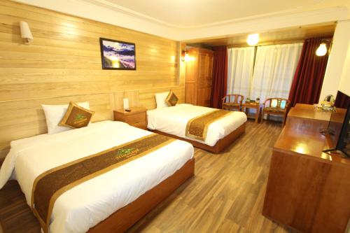 a hotel room with two beds and a television at Himalaya Sapa Hotel in Sa Pa