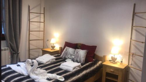a room with a bed with towels and two lamps at Vall del Riu - Llar dolça llar HUT07815 in Soldeu