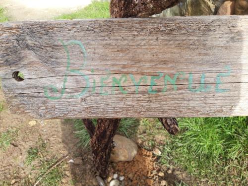 a wooden bench with writing on the back of it at Nid de Poussins in Vaumeilh