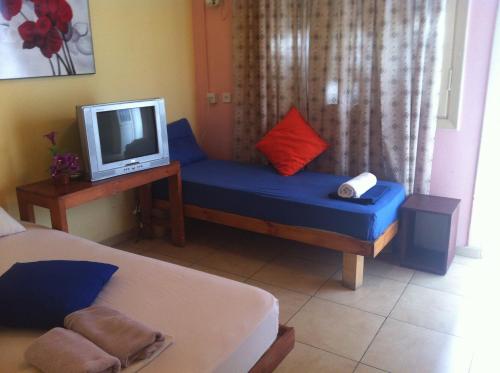 a living room with a blue couch and a tv at Hotel 28 in Tel Aviv