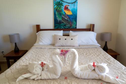 two swans made out of towels on a bed at Caye Reef Condos in Caye Caulker