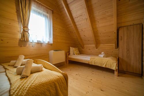 a bedroom with two beds in a log cabin at Eko domki MaMastra Szaflary in Szaflary