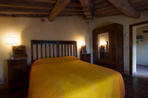a bedroom with a yellow bed and a mirror at Casa Benoi in Rigomagno