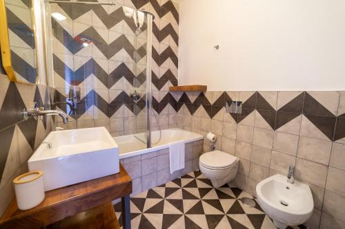 un bagno con lavandino, WC e vasca di Design Apartment Next Sorbillo on Tribunali St By HouseinNaples a Napoli