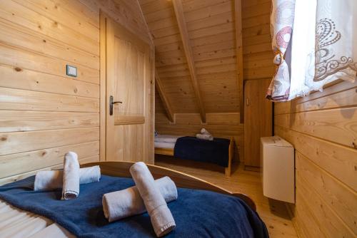 a bedroom with a bed in a wooden cabin at Eko domki MaMastra Szaflary in Szaflary
