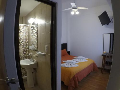 a bathroom with a bed and a sink and a mirror at BALOO Hotel in Mar del Plata