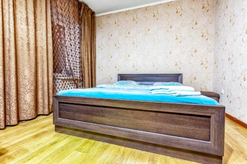 1 dormitorio con 1 cama y suelo de madera en 434 Апартаменты на Арбате Самый центр Отлично подходят для командированных и туристов, en Almaty