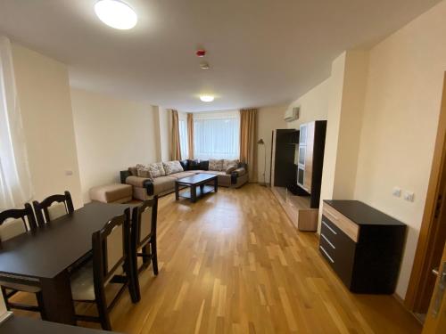 a living room with a table and a dining room at Pravets Resort Apartments in Pravets