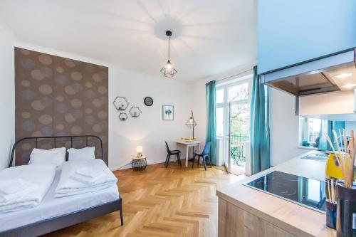 1 dormitorio con 1 cama y cocina con mesa en Slavikova 18 en Praga