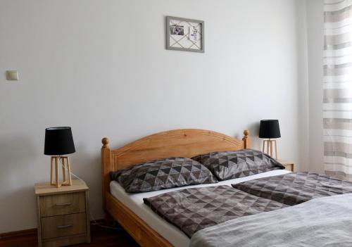 een slaapkamer met een bed en 2 lampen op een nachtkastje bij Orchidea Apartman Pécs in Pécs