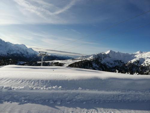 a snow covered slope with a ski lift on a mountain at Apartment "Casa Maya" in Mezzana