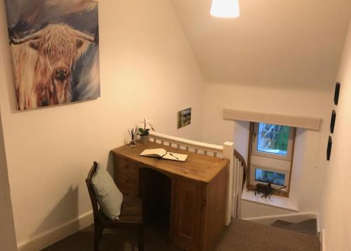 a room with a table and a picture of a cow on the wall at Carrick House in Kingussie