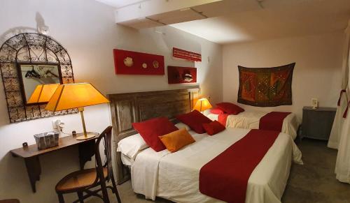 1 Schlafzimmer mit 2 Betten, einem Schreibtisch und einem Spiegel in der Unterkunft Barrio Boutik Hostal in Alicante