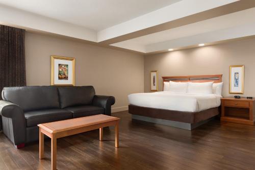 a hotel room with a bed and a couch at Royal Hotel Calgary, Trademark Collection by Wyndham in Calgary
