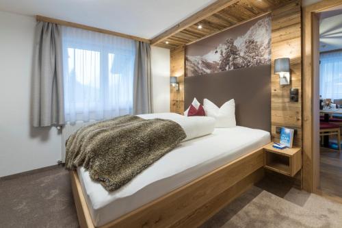 a bedroom with a large white bed with a window at Apart Garni Sesvenna in Ischgl