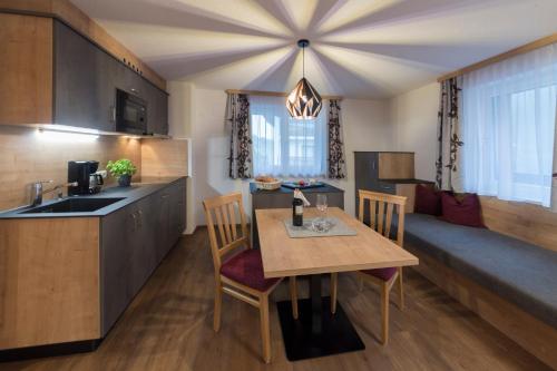 a kitchen and dining room with a table and a couch at Apart Garni Sesvenna in Ischgl