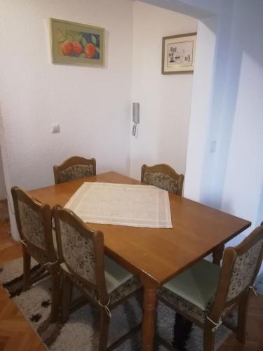 a wooden table with chairs and a table cloth on it at Apartman Luka in Kupres