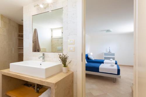 a bathroom with a sink and a bed at VILLA BIANCA con piscina e vista mare in Gagliano del Capo